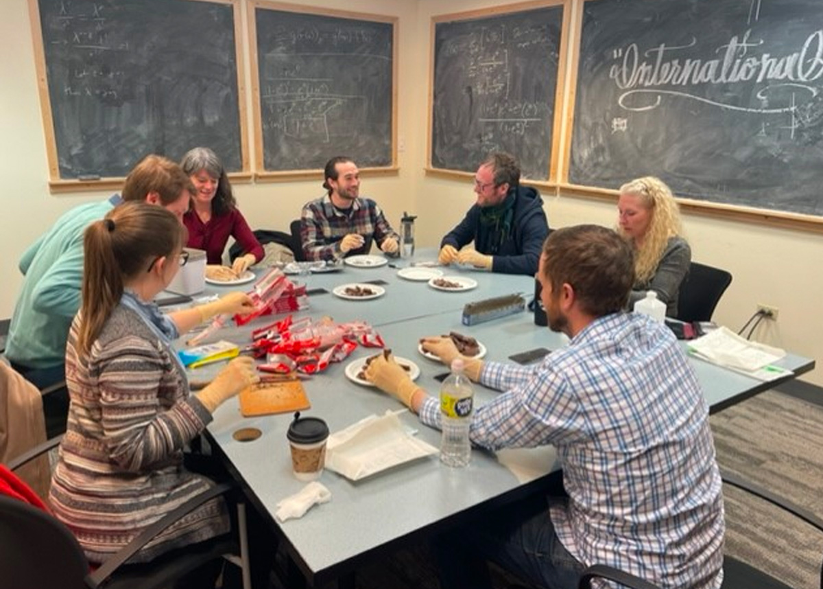 EpiDay2023 People sitting around table, teaching on epidemiology day