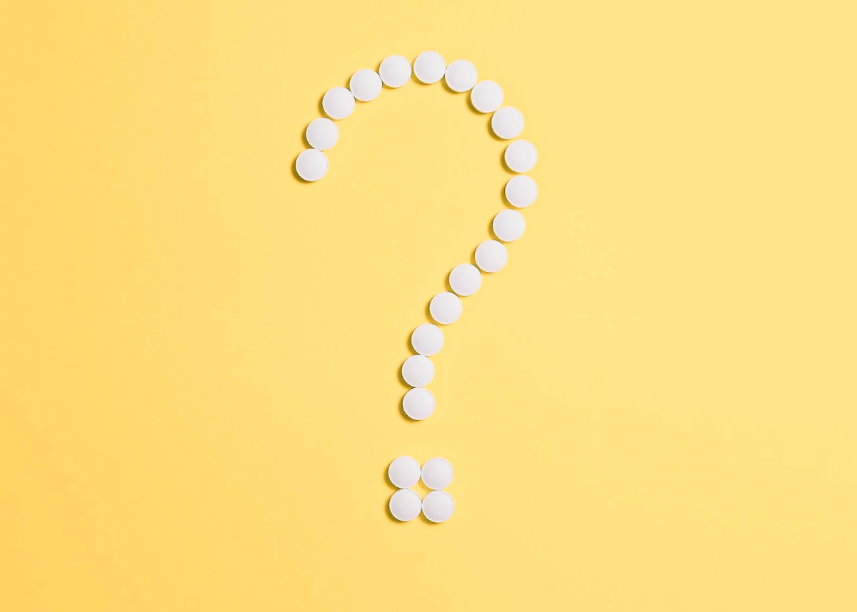question mark made of pills on yellow background